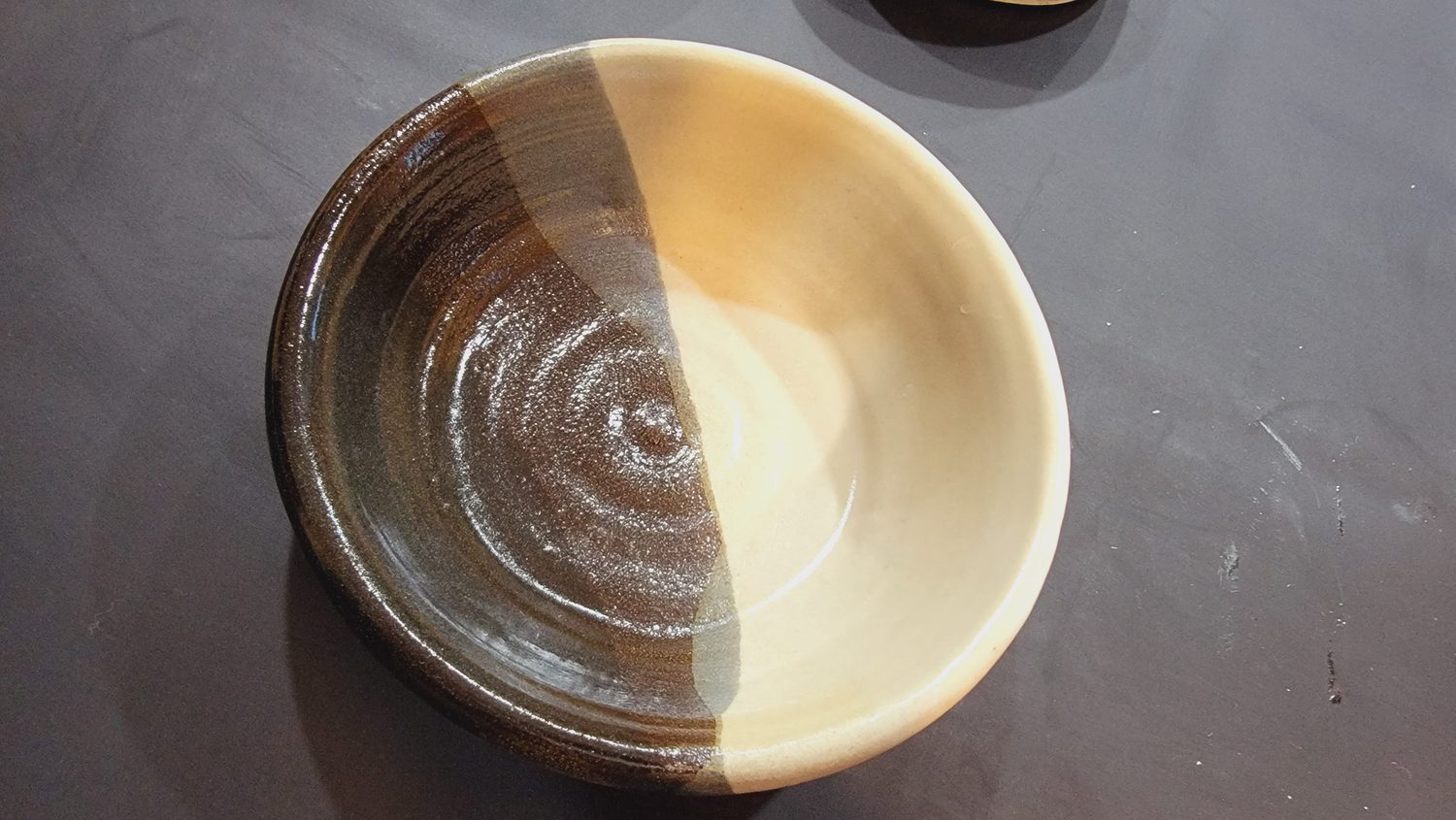 A thrown stoneware bowl with a two-tone glaze