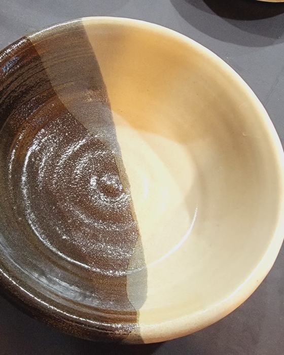 A thrown stoneware bowl with a two-tone glaze