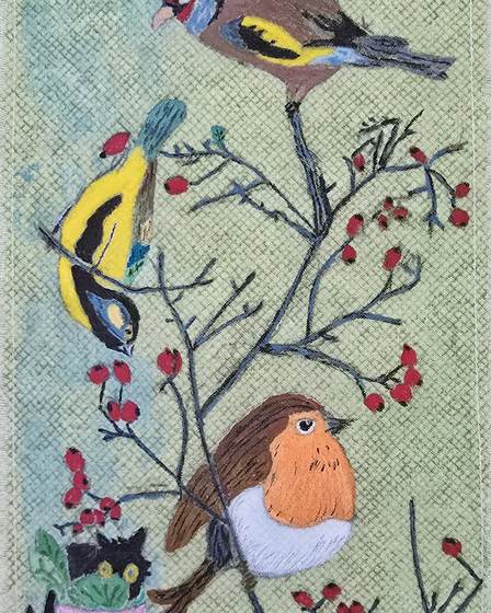 An embroidered quilt square showing a bird on a berry branch
